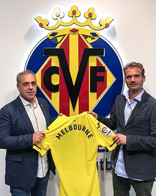 Holding a Melbourne shirt in front of the Villarreal CF crest